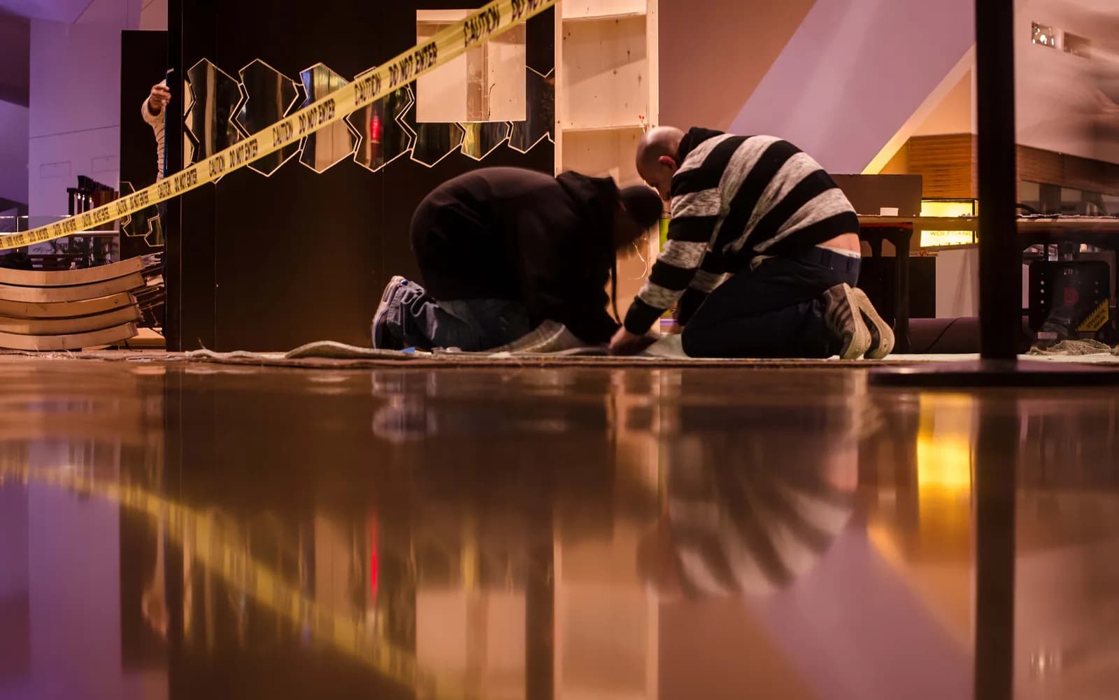 Install crew assembling the Serpenti pop-up on a polished mall floor behind caution tape