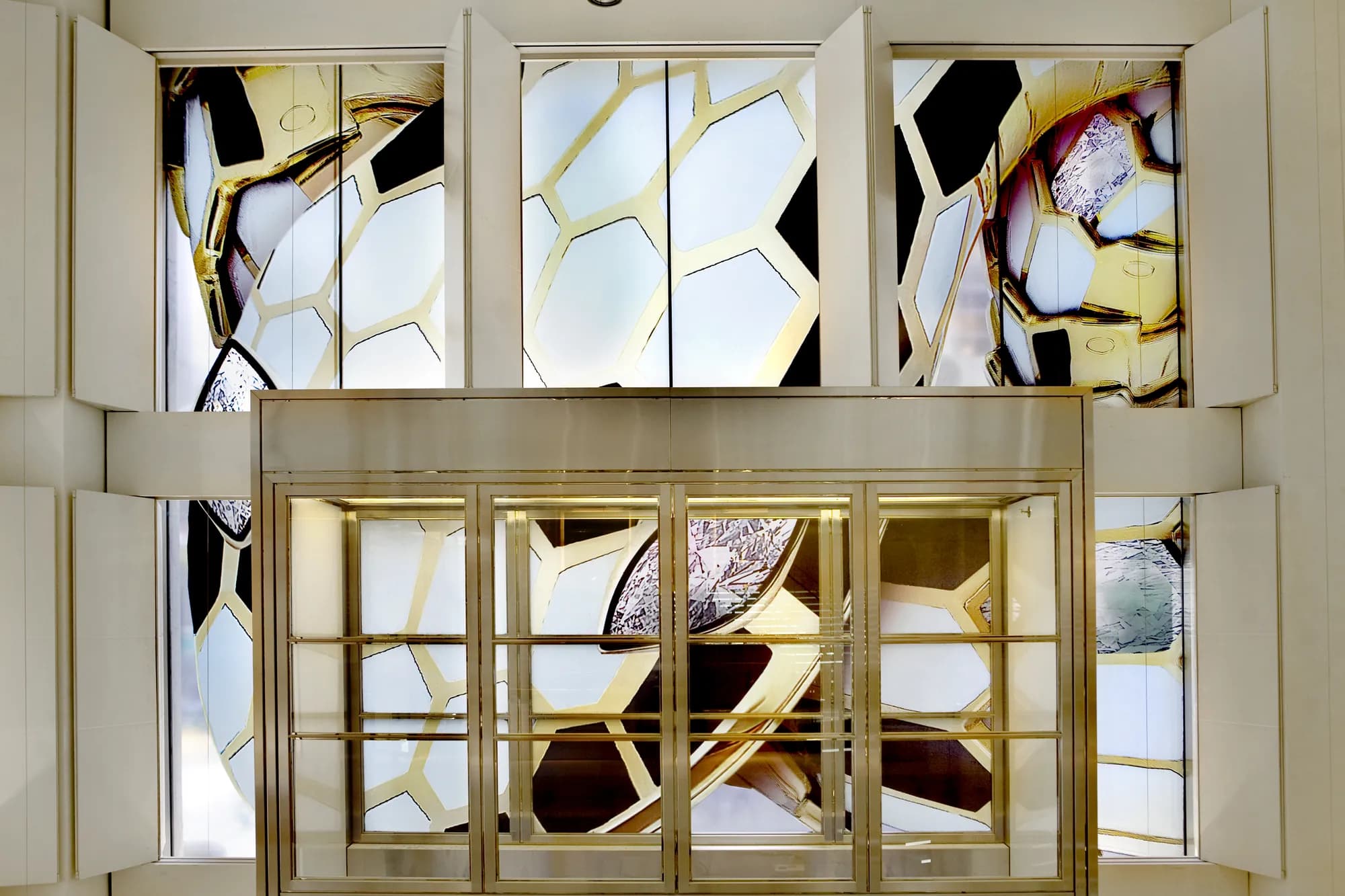 Bulgari entrance with brass revolving door set into large Serpenti scale window graphics