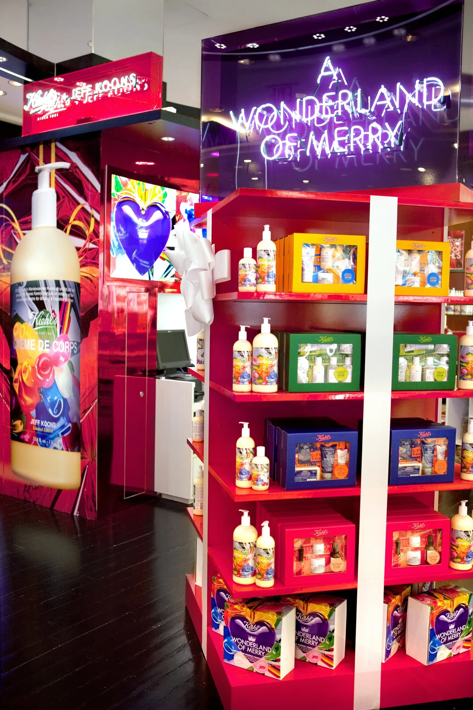 Kiehl's holiday pop-up with neon 'A Wonderland of Merry' sign and red shelving