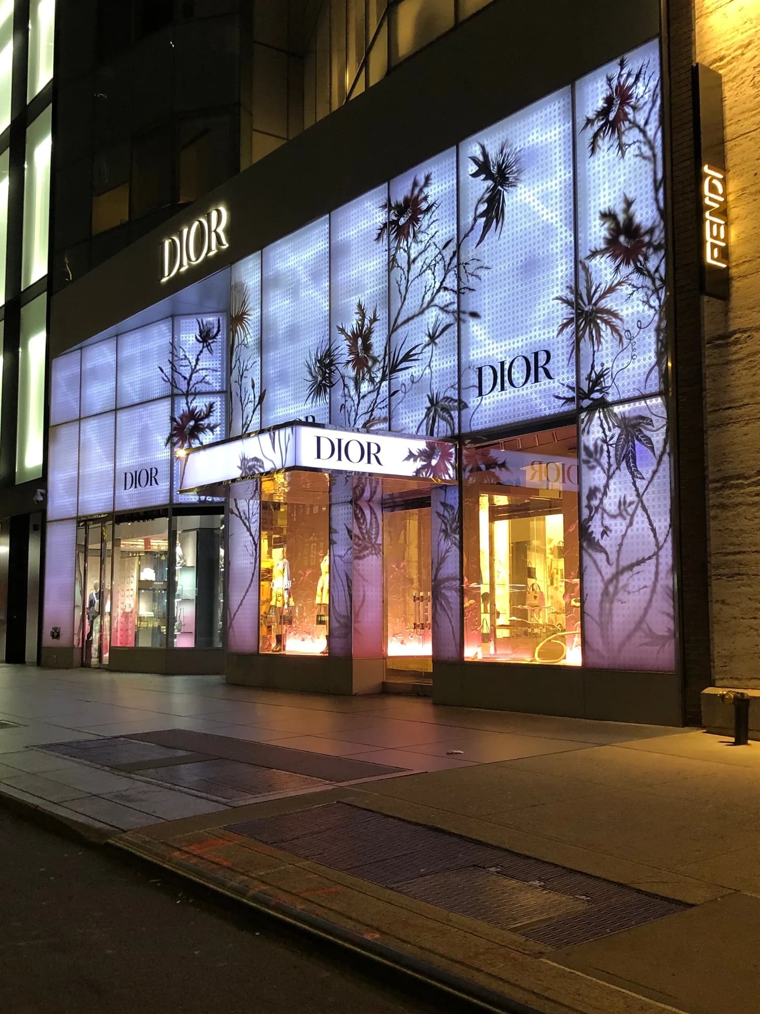 Dior 57th Street storefront with glowing lavender floral facade panels and lit windows