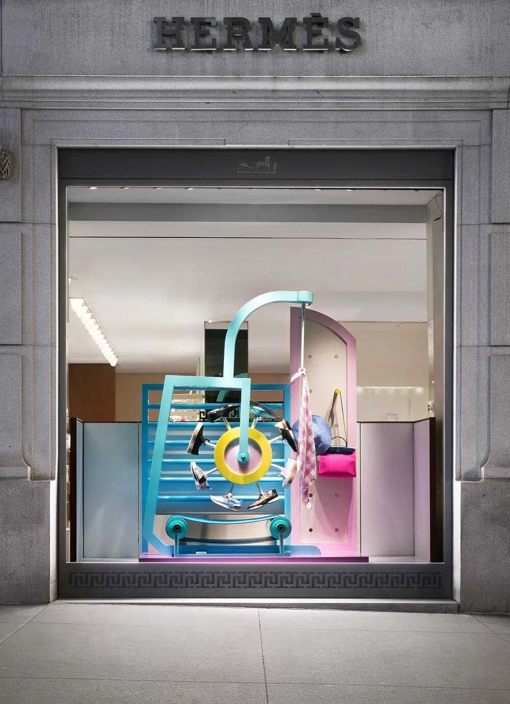 Hermès window with a turquoise ring-and-ladder sculpture in pastel tones