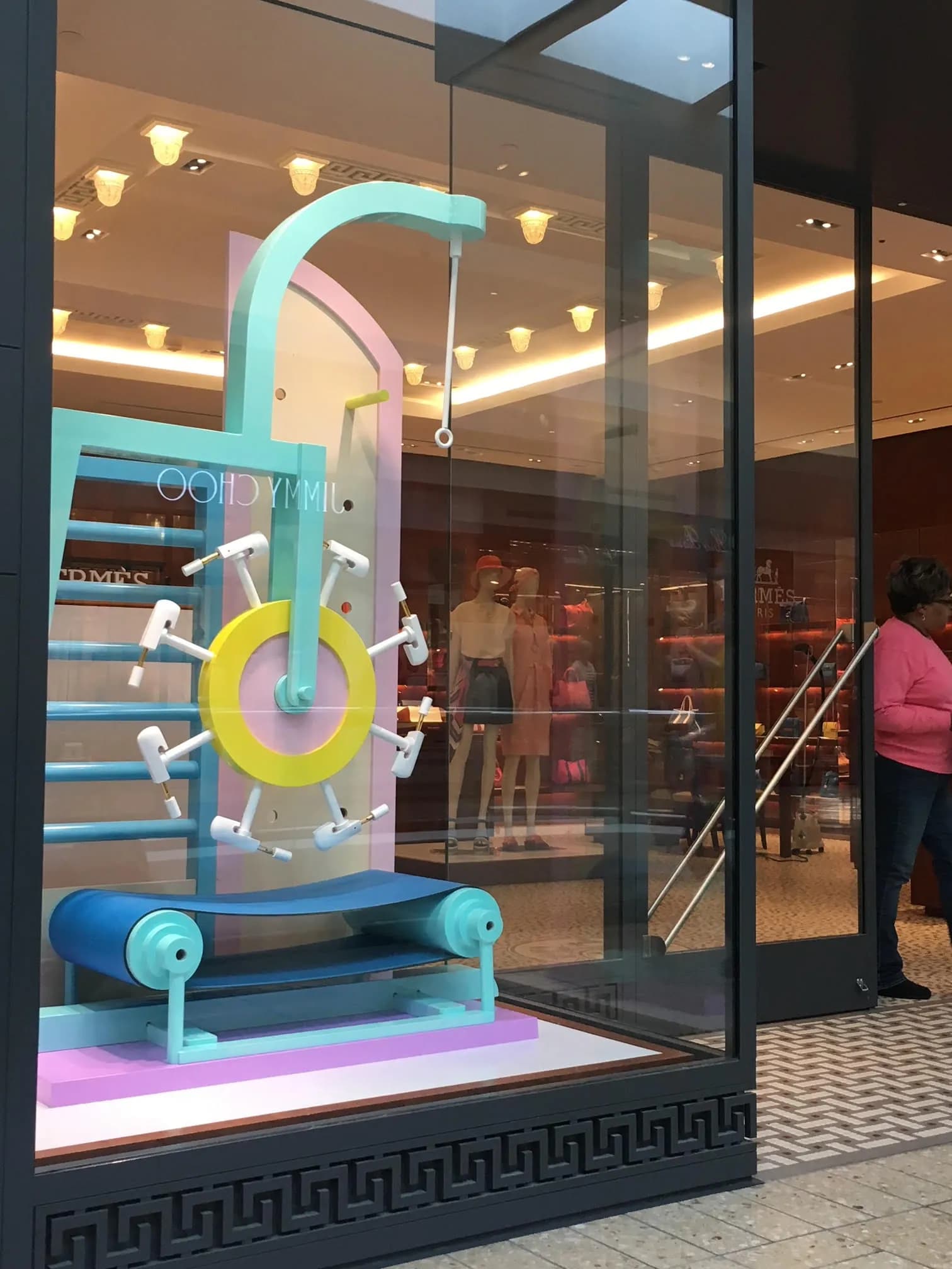 Hermès window with a lilac, turquoise and yellow wheel sculpture
